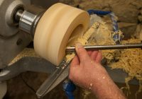 a man is working on a piece of wood